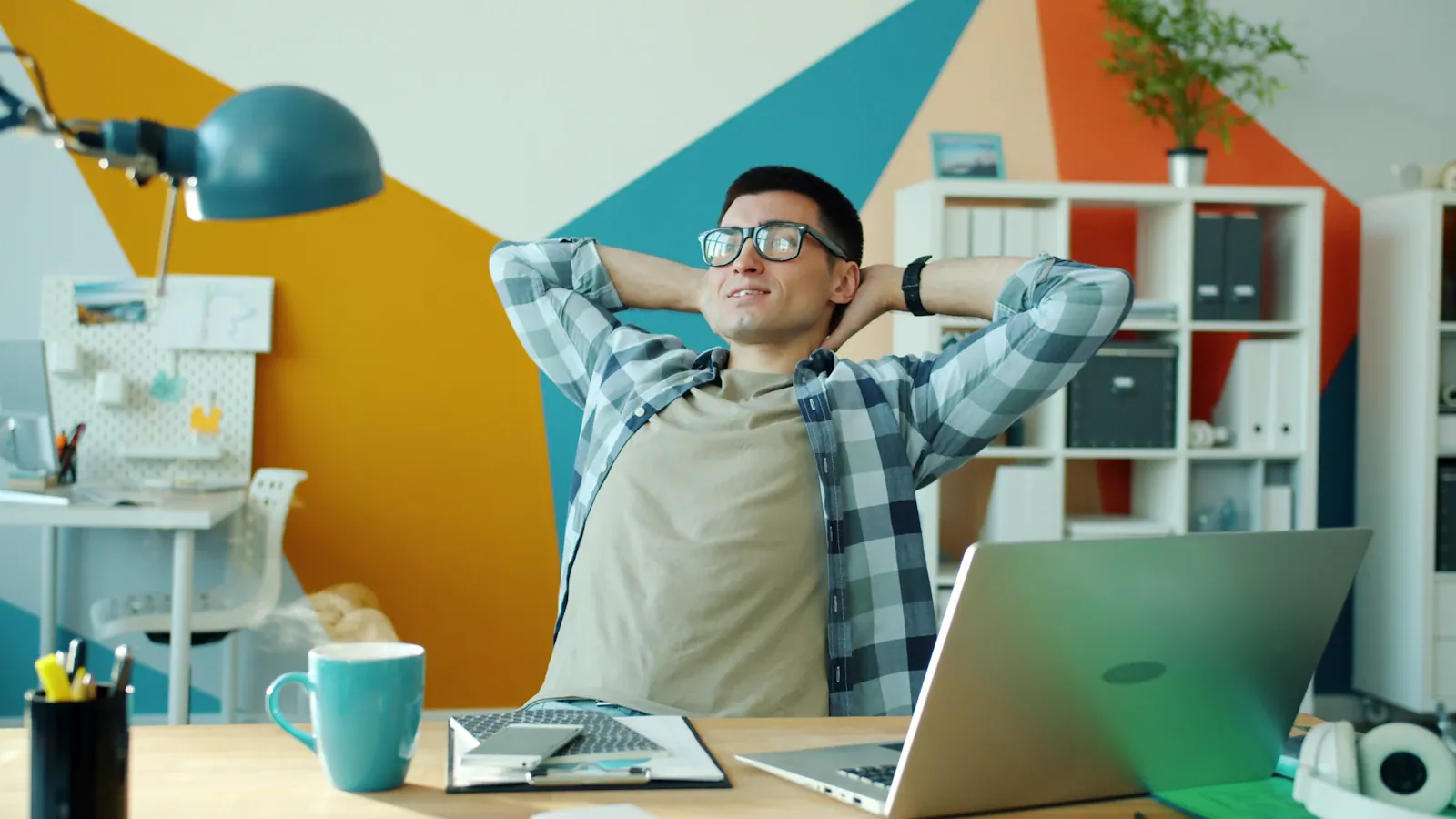A relaxed founder at his desk in a colourful office