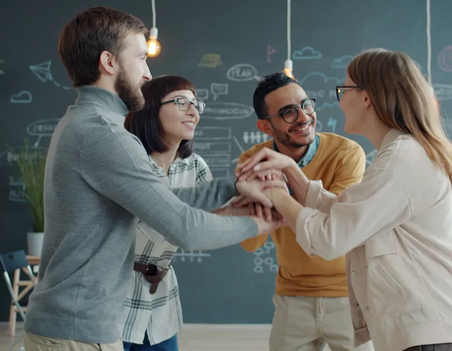 A team stacking hands in a bright office